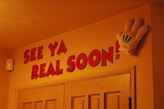 there is a sign on the wall that says see ya real soon with gloves hanging above it