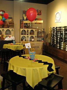 tables and chairs in a room with balloons on the wall