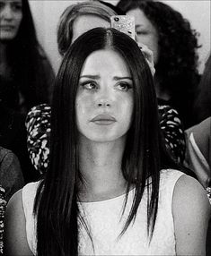 a black and white photo of a woman with long hair in front of other people