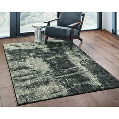 a black and white area rug with a chair in front of a large glass window