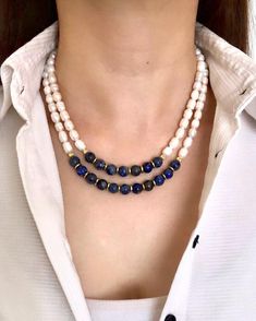 Lapis Lazuli and Genuine Natural Pearl Multistrand Beaded Necklace ✅ NECKLACE FEATURES * Handmade item * Materials: 10 mm High Quality Lapis Lazuli Natural Stone, Genuine Freshwater Natural Pearl, gold color hematite stone, gold-plated dorica and chain * Lenght:  48 cm/19 inches + 5 cm/2 inch adjustment chain. If you need a longer additional extension chain, please inform me. * There may be some color discrepancies due to different monitor settings. * Please note that natural stones may vary slightly in size, shape, and color tones from each other due to their natural characteristics. These small differences make your jewelry special and unique. ⭐️ This elegant women's necklace is designed with navy blue lapis lazuli and genuine natural pearls, arranged in two strands. Enhanced with gold-p Blue Beaded Pearl Necklace For Wedding, Blue Gemstone Beads Necklace For Wedding, Blue Single Strand Beaded Necklace For Wedding, Blue Pearl Chain Jewelry For Wedding, Elegant Blue Pearl Beaded Necklaces, Blue Single Strand Wedding Necklace, Blue Double Strand Pearl Necklace Gift, Blue Double Strand Pearl Necklace For Gift, Blue Pearl Chain Necklaces For Wedding