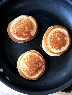 three pancakes are being cooked in a skillet