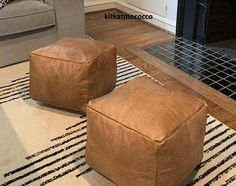 two brown ottomans sitting on top of a rug