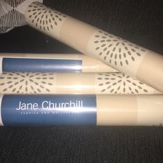 three baseball bats sitting next to each other on a black cloth covered surface with the name jane churchill printed on them