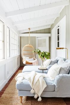 a living room filled with furniture and a hanging chair