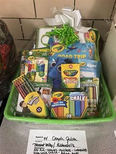 a green basket filled with school supplies on top of a counter next to a sign