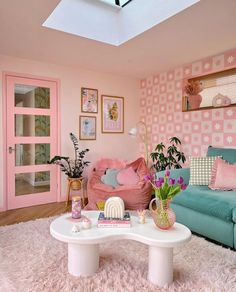 a living room with pink and blue furniture, rugs and pictures on the wall