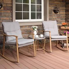 two rocking chairs sitting on top of a wooden floor next to a table with flowers