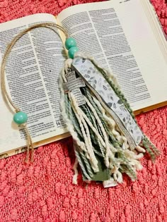 an open book with tassels and beads on it