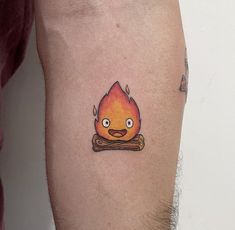 a man with a tattoo on his arm that has a cartoon fire in the middle