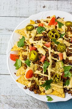 a white plate topped with nachos covered in cheese