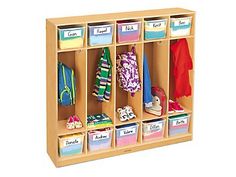 a wooden cubby with several bins and clothes hanging on the wall next to it