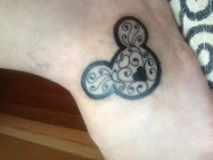 a black and white tattoo on the foot of a person with a butterfly in it