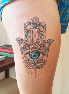 a woman's thigh with a hamsa tattoo on it and an eye in the middle