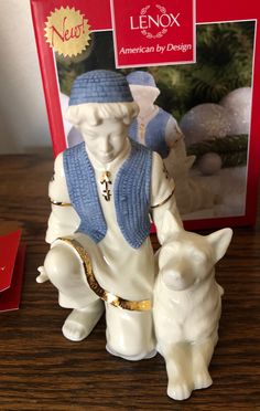 a figurine sitting on top of a wooden table next to a boxed lenox box