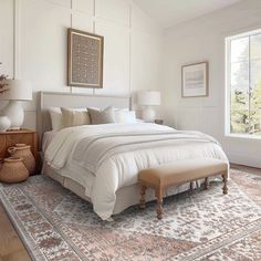 a bedroom with a large bed and two windows in the wall, along with an area rug on the floor