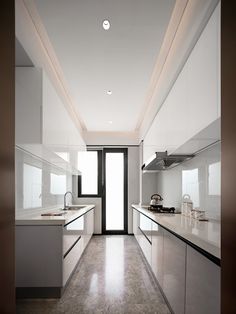 an empty kitchen with stainless steel appliances and counter tops is seen in this image from the doorway