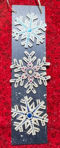 two snowflakes are hanging on a red carpet