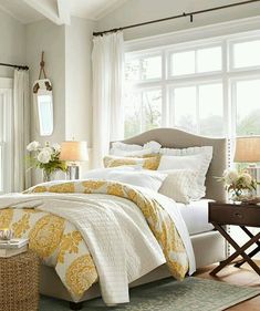 a bedroom with white and yellow bedding