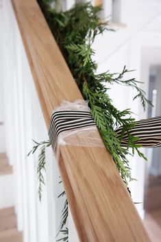 a close up of a wooden rail with green plants on it