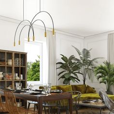 a living room filled with furniture next to a large potted plant and a window