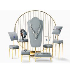 an assortment of jewelry is displayed in a display case with gold accents and blue velvet upholstered chairs