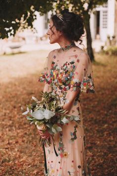 a woman in a floral dress holding a bouquet