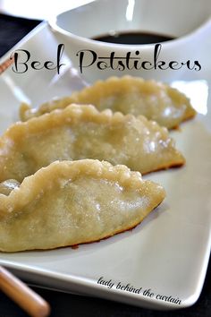 two dumplings on a white plate with chopsticks next to it and a cup of coffee in the background