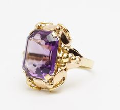 Vintage French Made  Emerald Cut Amethyst Solitaire  14K Yellow & Rose Gold Ring  Size US between 6 3/4-7 Weight: 7 grams Amethyst measures approx. 19.6ct Head of Ring measures approx. 21.8mm x 20.5mm This is a pre-owned item in Good Condition. It does show signs of use/wear but there is still lots of life left to this ring.  This ring is not stamped, but it has been tested by our Niton DXL metal analyzer which read as 14K gold. There is a maker's mark inside the band, which we believe to be French origin.  (CAT E 24-50201) Art Deco Yellow Gold Amethyst Ring For Formal Occasions, Formal Yellow Gold Amethyst Ring With Bezel Setting, Elegant 14k Gold Amethyst Ring With Polished Finish, Elegant Yellow Gold Amethyst Ring For Anniversary, Luxury 14k Gold Hallmarked Amethyst Ring, Formal Yellow Gold Amethyst Ring With Polished Finish, Elegant Yellow Gold Amethyst Ring With Bezel Setting, Art Deco 14k Gold Amethyst Ring For Formal Occasions, Formal 14k Gold Art Deco Amethyst Ring