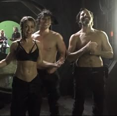 three shirtless people standing in front of a green screen with their hands out to the side