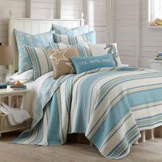 a bed covered in blue and white striped comforters