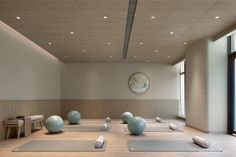 an empty room with yoga mats and exercise balls