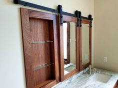 a bathroom with marble counter top and wooden doors