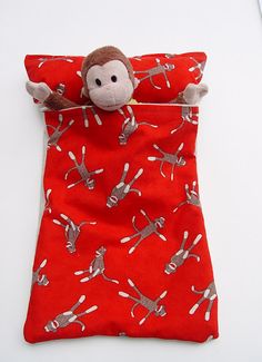 a stuffed monkey is laying in a red bag