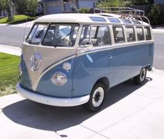 an old vw bus is parked on the side of the road in front of a house