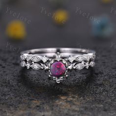 a close up view of a ring with a pink stone in the center