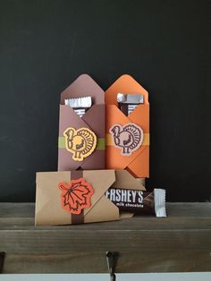 four different colored paper bottle openers sitting on top of a shelf