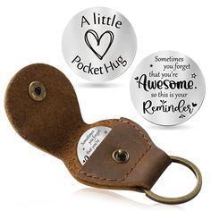 two leather keychains with magnets on them, one has a heart and the other has a quote