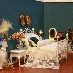 a doll house bedroom with white furniture and accessories on the floor, including a bed