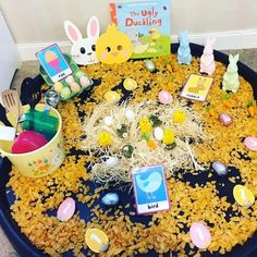 an easter basket filled with eggs, rice and peeps on top of a table