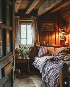 a bedroom with wood paneling and plaid comforter on the bed in front of a window