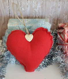 a red knitted heart sitting next to presents