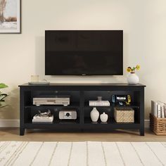 a flat screen tv sitting on top of a black entertainment center next to a white rug