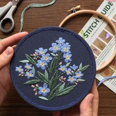 someone is stitching some flowers on a piece of fabric