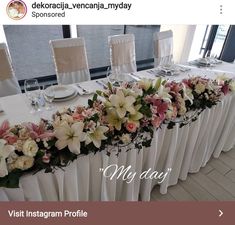 the table is set with white and pink flowers