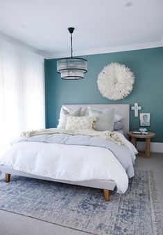 a bedroom with blue walls and white bedding