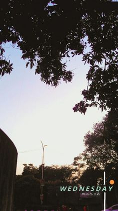 the sun shines brightly in front of a business sign and traffic lights on a city street