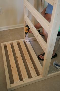 a man is working on the bottom bunk of a bed with no mattresses or sheets