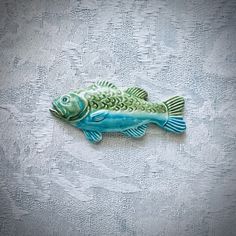 a blue and green fish sitting on top of a table