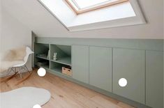 an attic bedroom with skylight and storage units in the corner, along with a white rug on the floor